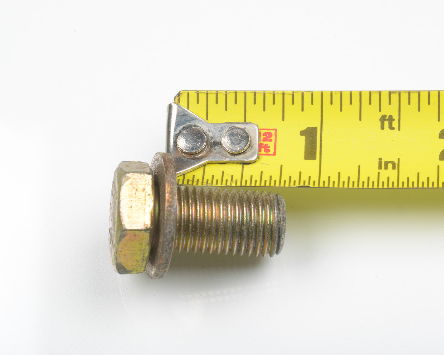 Metal bolt with a measuring tape showing its size on a white background