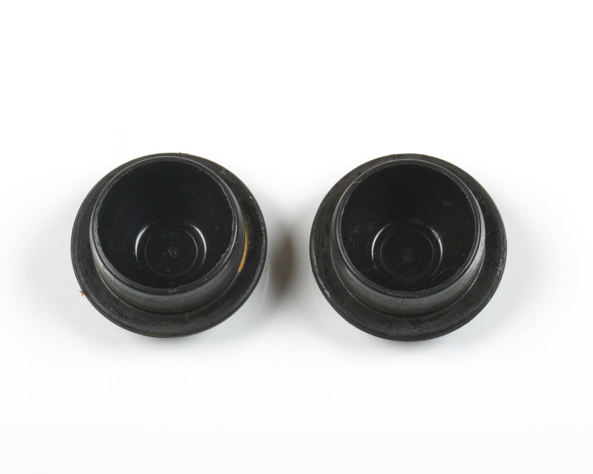 Two black circular plastic or rubber components with a flanged base, shown from a top-down view on a white background.