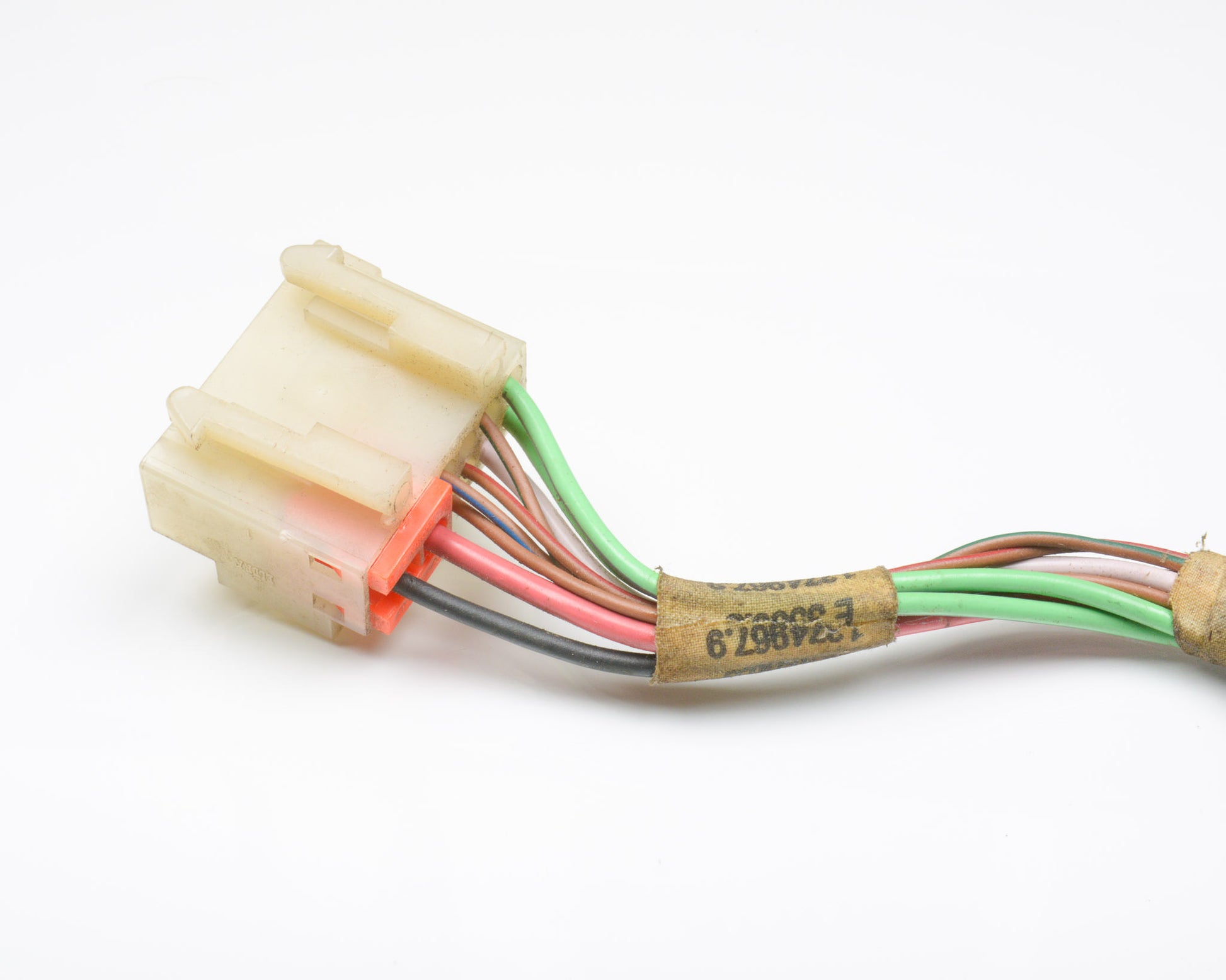Close-up of a wiring harness with colored wires on a white background