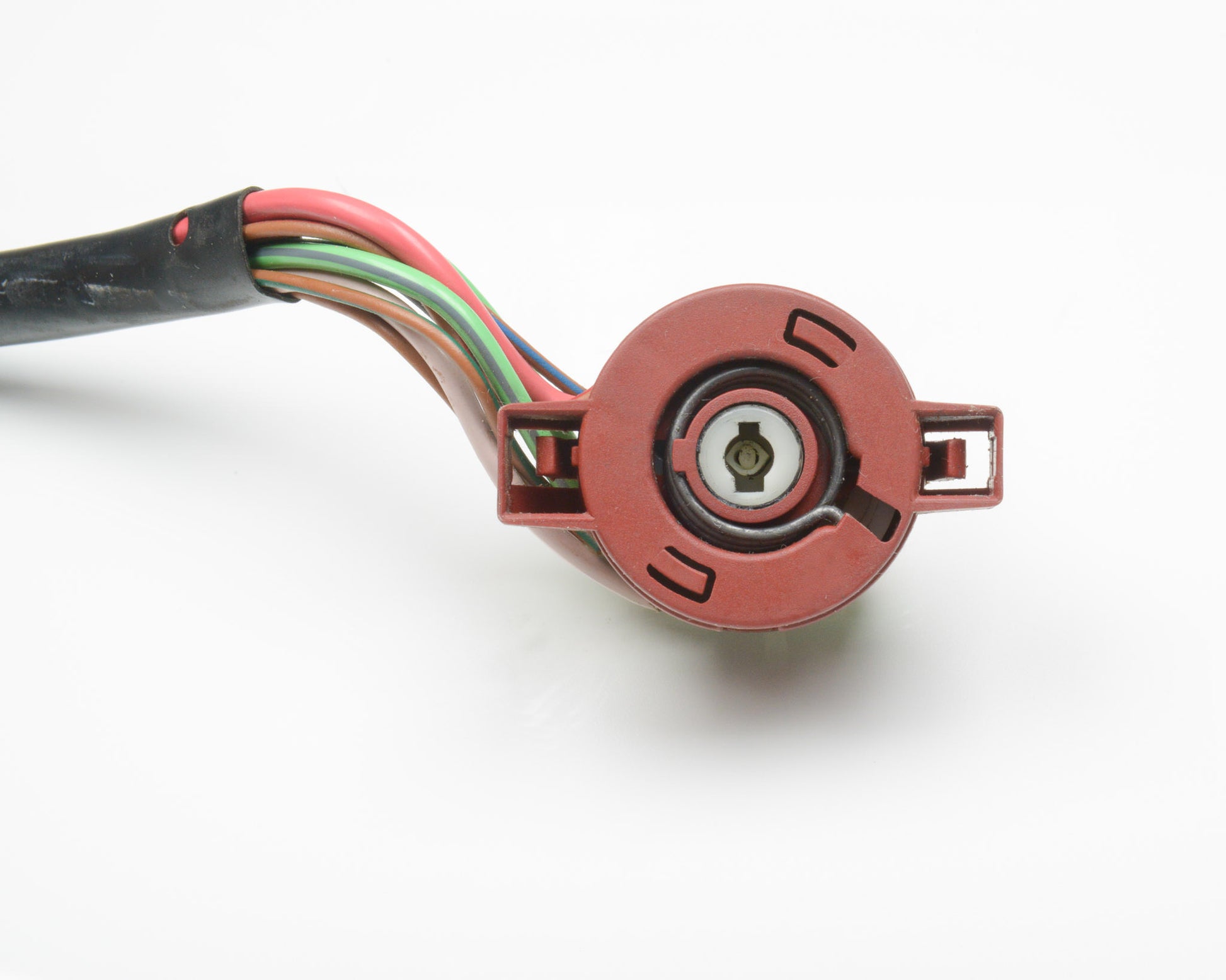 Close-up of a red electrical connector with multicolored wires on a white background